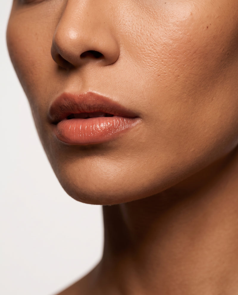 Close-up of Selena wearing Coral Nude tinted lip balm